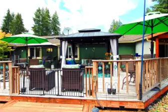 This inviting back deck creates an ideal space for relaxation and entertaining.  Enjoy cozy evenings under the cover, all while taking in the beauty of the backyard.