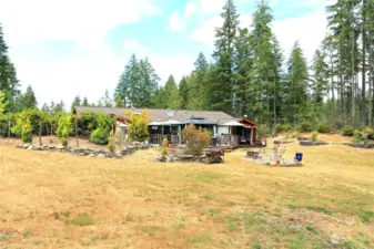 This photo captures the back of the house from the large backyard, showcasing its inviting design and spacious layout.