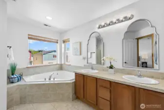 The primary bath features double vanity sink, separate shower, and large corner tub!