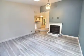 Family room with wood burning fireplace, skylight and ceiling fan