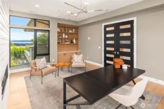Library features custom built in rift oak shelves with lower cabinets and slab top. Custom built stained rift oak double doors and designer light fixture finish out the space