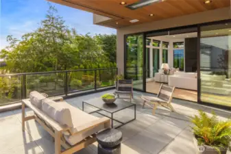 Expansive covered area with fine line cedar ceiling and flush mounted ceiling heaters elevate the inside/outside living