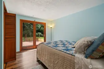 Primary bedroom with French doors to back deck and fenced back yard