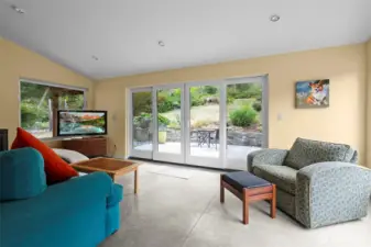 This space is very flexible. It has a wood fireplace for those chilly winter evenings, and large sliding doors to enhance indoor/outdoor living.