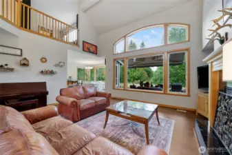 Sunlit living room with vaulted ceilings and designer windows.