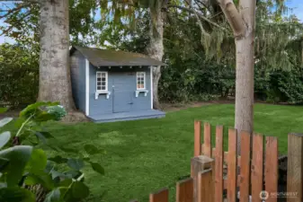 View of the storage shed and backyard from the carport.