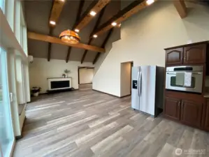 Kitchen/dining area with large electric fireplace and mini-split. High ceiling and fan for temp distribution
