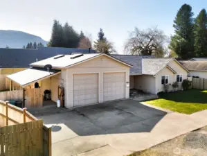 Spacious attached garage with ten foot tall garage doors and covered caport attached to side.