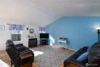 Living room is spacious with vaulted ceilings.