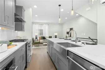 Sink and dishwasher in island and refrigerator, built-in microwave, and gas range against wall. All Kitchen-aid appliances.