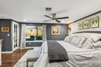 Large lower level primary bedroom ... nothing about it feels "under ground"! Look at those gleaming floors and large windows, allowing the outdoors in!