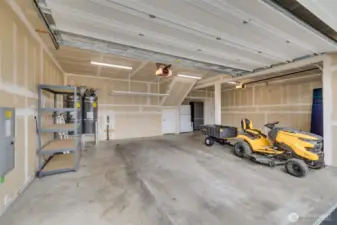 Three car garage with an extra fridge and above head storage.