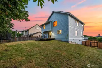 Slight slope in fenced-in backyard. Low-maintenance landscaping ideal for busy lifestyles. Lots of room to play.