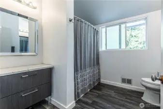 Upper bathroom has additional vanity and storage area.