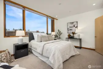 The primary bedroom has large, east-facing windows