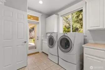 Spacious laundry room with a sink and ample counterspace and storage.