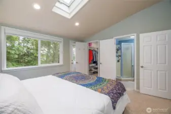 A view to the walk in closet in the primary bedroom, plus the attached "jack and jill" bathroom.