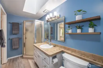 This 3/4 bathroom is accessible from the primary bedroom and the hallway.