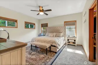 Primary bedroom en suite and walk in closet. Wood wrapped windows, ceiling fan