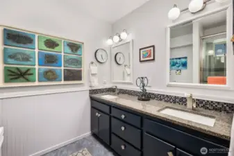 Primary bathroom with skylight, dual sinks and walk-in shower.