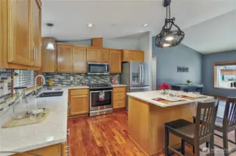 Quartz counters, stainless steel, and a breakfast bar - your kitchen trifecta