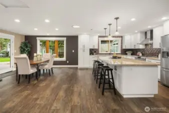 A stunning kitchen remodel with shaker cabinets, quiet-close drawers and pull-outs, granite countertops, stainless steel appliances, and a large eating island. GE dual oven and KitchenAid refrigerator.