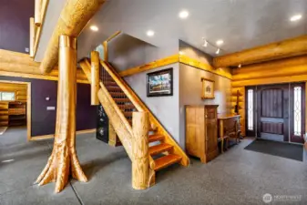 Heated exposed aggregate floors allow the bold live-edge architecture to shine through.  Note the fabulous main beam and the split log stairs.  The interior of the home says "Luxury Lodge" in every detail.