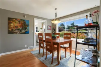 The dining room offers wonderful light, easy access to the kitchen and a built-in cabinet/buffet.