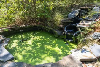 Pond feature with waterfall behind playset.