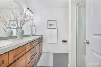 Ensuite bathroom with dual sinks and builder upgraded countertops and tile floor.