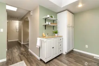 More cabinetry and hallway leads to foyer, living room and bedrooms.