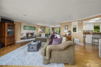 The designer earth tones and warm-toned hardwood flooring create a very calming and soothing atmosphere in this spacious living room. The Brick/Gas-Log Fireplace, Crown Molding and Recessed Lighting add to its comfort, elegance and charm.
