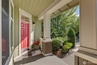 A bold red front door and crisp white trim create a striking first impression, with a spacious covered porch that offers a convenient spot to pause—perfect for removing shoes, collecting packages, or greeting guests out of the rain.