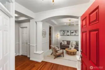 Step inside to a gracious entry with rich hardwood floors, elegant column details, and freshly painted walls—offering a warm welcome and a glimpse of the style that continues throughout.
