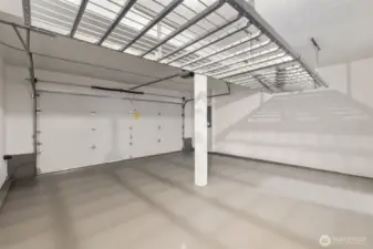 This spacious two-car garage features freshly primed and painted walls and flooring, creating a clean, finished look. A ceiling-mounted storage rack (installed in 2020) adds convenient overhead organization, while the automatic garage door opener (new in 2019) brings modern ease to your daily routine.  The home's two-car garage is located at the rear and backs to a privately owned wooded lot—offering both easy access and a peaceful, tucked-away setting.
