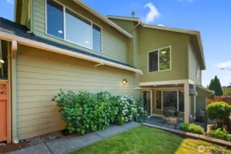 A lovely terraced backyard with a vibrant lawn, lush hydrangeas, and mature plantings—fully fenced for privacy and peace of mind.