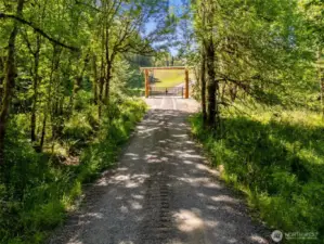 Standing near NE corner looking at entry gate. Translation, the gate is not on the property line but set into the property about 100'