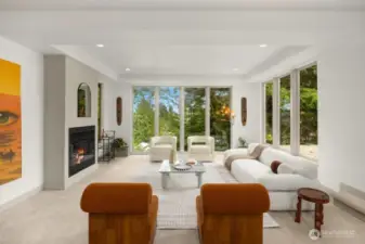 Sunken living room with floor to ceiling windows  for plenty of natural light and stunning view of nature