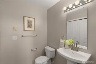 Updated powder room with new sink, faucet, vinyl flooring, and a convenient side-by-side washer/dryer closet