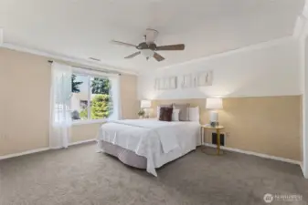 Large upstairs primary suite, complete with ceiling moulding and ceiling fan.