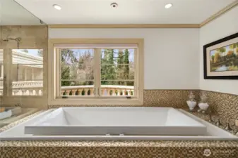 Spa-inspired primary bath featuring a walk-in shower, soaking tub, dual vanities, and refined stone finishes.