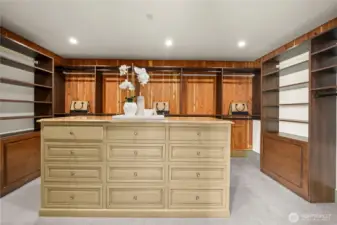 Spacious walk-in closet with custom built-ins and center island for organized, boutique-style storage.