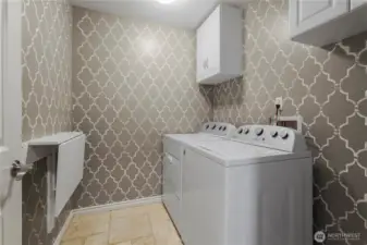 Main floor laundr room with cabinets and folding table.