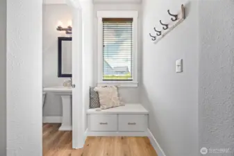Foyer bench and coat storage. 1/2 bath on left.