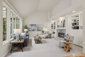 Adjacent informal gathering room with tall vaulted ceiling and built-in cabinetry.