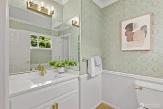 The guest 1/2 bath with quartz vanity, brushed gold faucet and lighting.