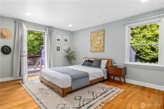 Primary bedroom on the main level. The primary bedroom has a private door to the backyard and a sunny deck.