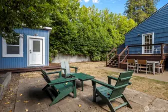 The fully fenced back yard has multiple gathering areas.