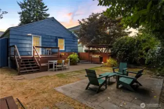 The fully fenced back yard has multiple gathering areas.