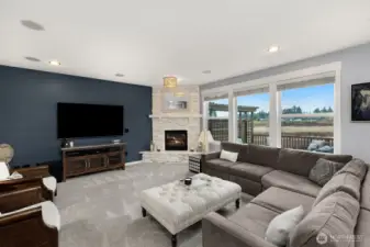 Spacious and bright family room with gas fireplace and serene views.
